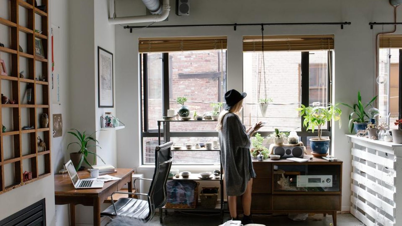 A designer working at a laptop in a bright home studio